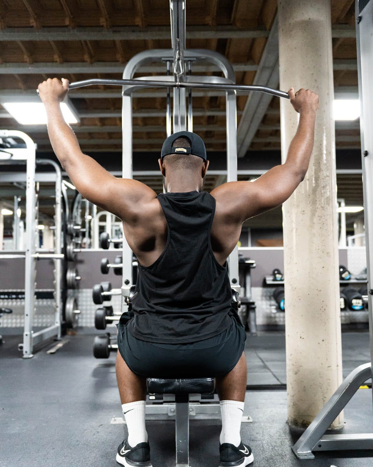 Un adhérent au tirage vertical sur le plateau de Gym Coach